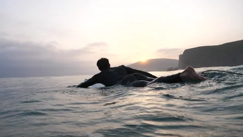 Underwater camera surfer paddling into sunset Stock Footage 274901257
