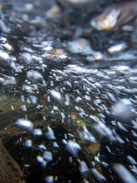 Underwater camera view of flowing stream with dynamic rushing bubbles Stock Photos