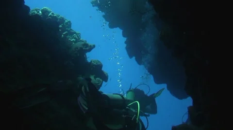Underwater CAVE Divers Exit through narrow opening Stock Footage 61178055