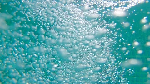 UNDERWATER CLOSE UP: Numerous small air bubbles rising up to surface in the pool Vídeo Stock 104305823