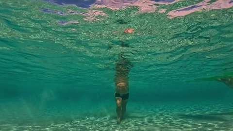 Underwater front view of man walking on seabed raising sand Stock Footage 278949974