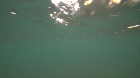 Underwater light rays and sunset over calm ocean waves 動画素材 311713764