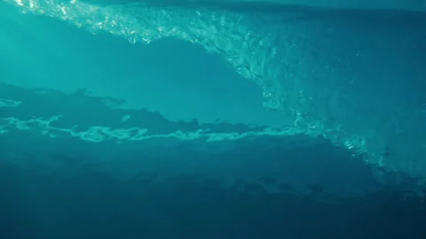 Underwater looking up rippling surface barrel crashing slow motion Stock Footage 333447071