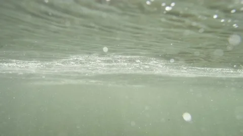 Underwater looking at the surface of the water with bubbles flowing in the river Video stock 168645817