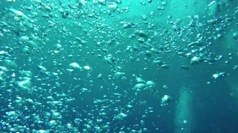 UNDERWATER MACRO: Many small air bubbles rising up to the smooth ocean surface Stock Footage 64406525