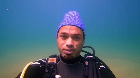 Underwater a man is looking to the camera then gives up Stock Footage 116486557