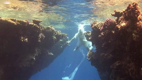 Underwater model free diver in costume pirate swims in clean water in Red Sea. Stock Footage
