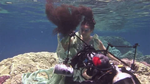 Underwater model free diver poses for camera on background of corals in Red Sea. Stock Footage