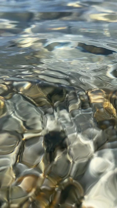 Underwater movement of waves over smooth stones Stock Footage 283485792