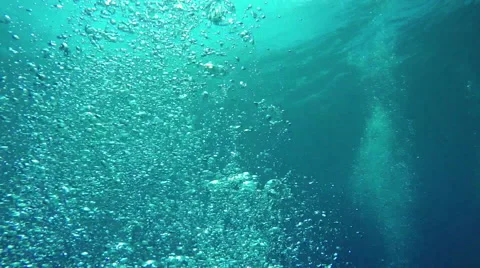 UNDERWATER: Numerous small air bubbles rising up to the smooth ocean surface Stock Footage 64406592