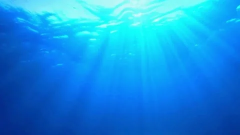 Underwater ocean waves deep blue ripple and flow with bright sun light rays Video stock 306340396