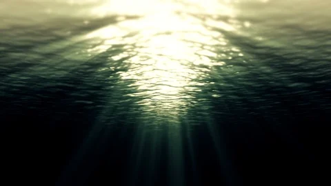 Underwater ocean waves ripple and light rays in dark water. 4K seamless Stock Footage
