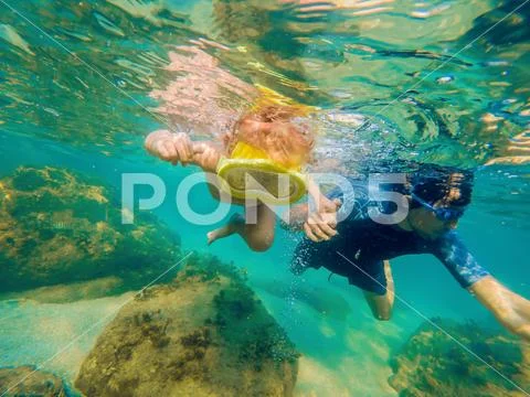 Underwater portrait of family snorkeling together at clear tropical ocean Stock Photos