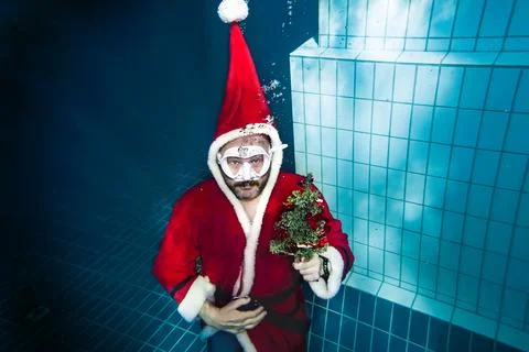 Underwater Santa Claus with a beautiful Christmas tree emerges from the depth Stock Photos