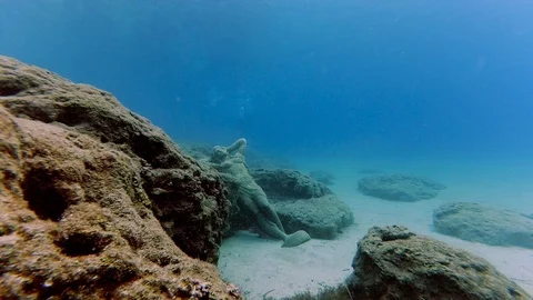 Underwater scene with the statue on the bottom of the sea and several divers Stock Footage 107417615