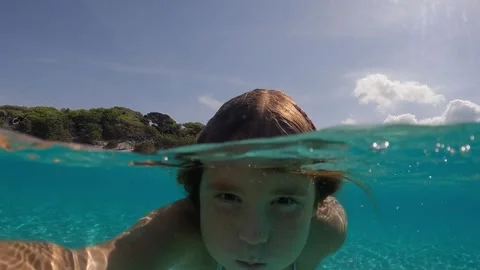 Underwater selfie of cute red-haired girl holding breath in transparent water 库存影片 278842753