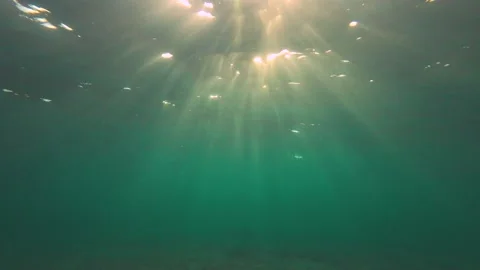 Underwater shot, Rays of the setting sun penetrate the surface of the water and Video stock 232771303