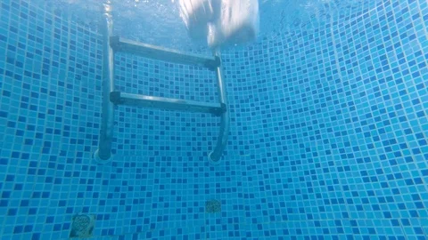 Underwater shot from a small round pool of a man jumping in the water making Video stock 119801238