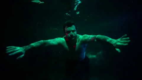 Underwater shot of swimming man, dramatic green light, dream or fantasy concept 動画素材 169704364