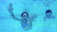 Underwater Shot Of Two Kids Diving In A Swimming Pool In Slow Motion Stock Footage