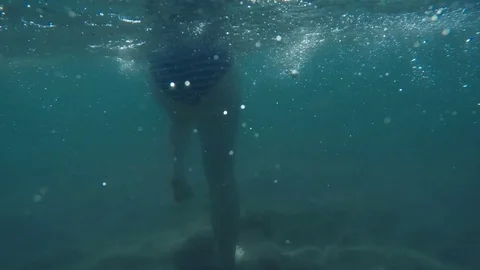 Underwater slow-motion back view of a woman walking in the ocean 库存影片 75407640