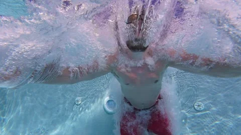 Underwater slow motion shot of man jumping into swimming pool at a hotel resort. Stock Footage 335334201
