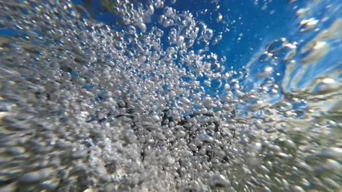 Underwater slow motion of twirling bubbles in a crystal clear water. Video stock 205928989