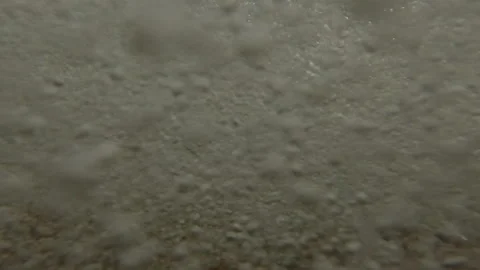 Underwater split level on coastal storm waves cover pebble beach and forms a 库存影片 333599579