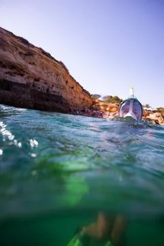 Underwater split shot of diver with snorkel by the seaside cliff Stock Photos