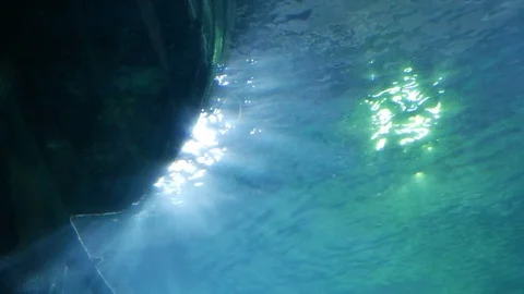 Underwater sun rays in the blue sea with tropical fish bottom of a boat Stock Footage
