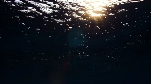 Underwater Sunset || Light beams breaking the waves Stock Footage 149964565