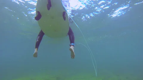 UNDERWATER: Surfer sitting on a surfboard Stock Footage 37694867