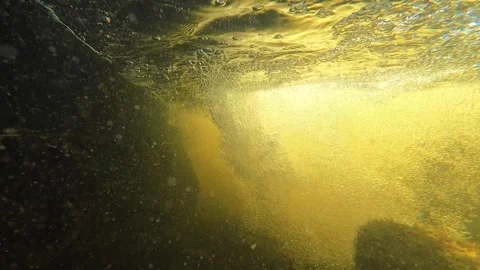 Underwater swirls beneath small cascade flowing from old concrete foundation Video stock 344059872
