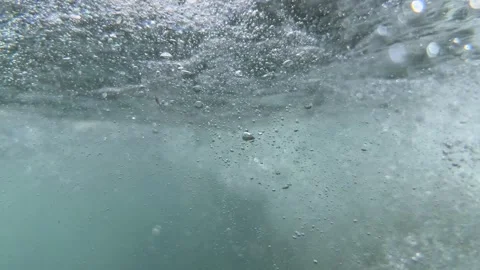 Underwater tidal movement creates a cloud of air bubbles drifting through seawat Stock Footage 344627096