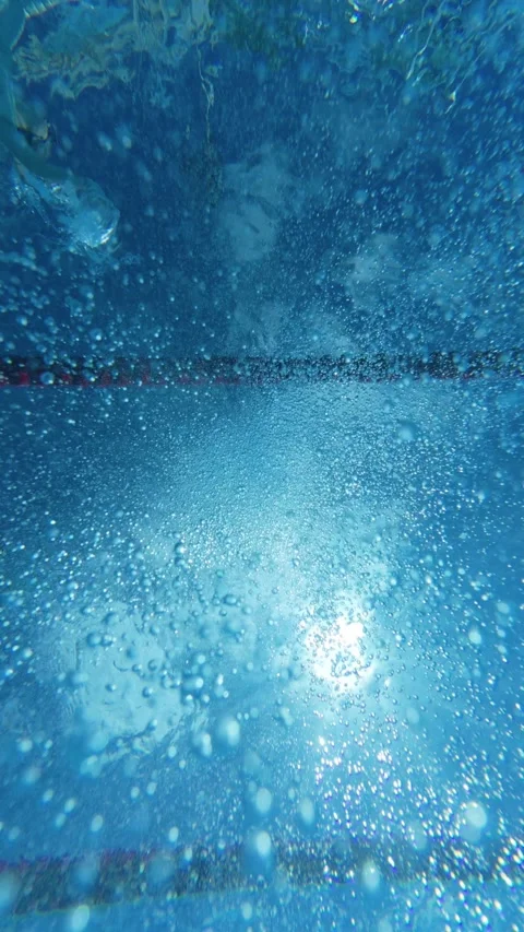 Underwater view of air bubbles and sunlight on swimming pool surface 動画素材 343937275