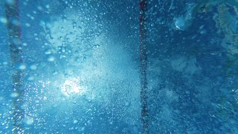 Underwater view of air bubbles and sunlight on swimming pool surface 動画素材 343937296