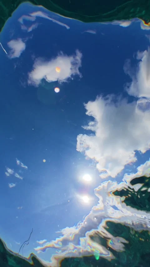 Underwater View of Blue Sky and Clouds with Sun Through Water Surface. Stock Footage 338369211