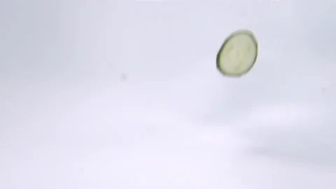 Underwater view dropping slicing of cucumber into water Stock Footage 121221577