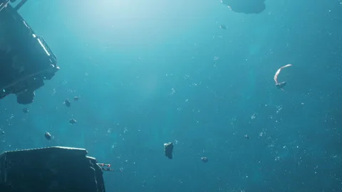 Underwater view of floating objects and divers exploring in blue depths Stock Footage 348763192