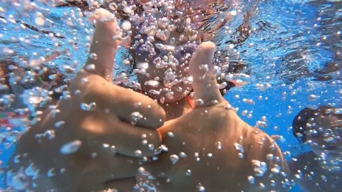 Underwater view of having fun children jumping and diving into swimming pool Stock Footage 120111050
