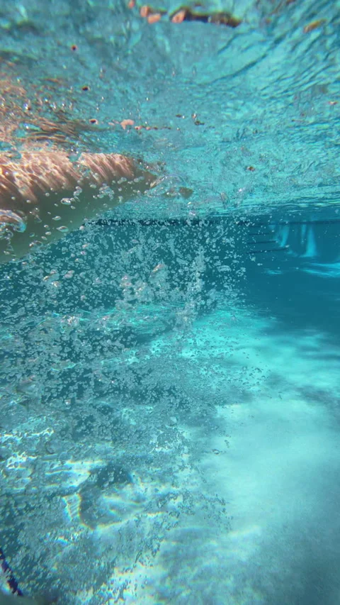 Underwater View of Legs Kicking Through Turquoise Pool Water with Air Bubbles. Stock Footage 340543394