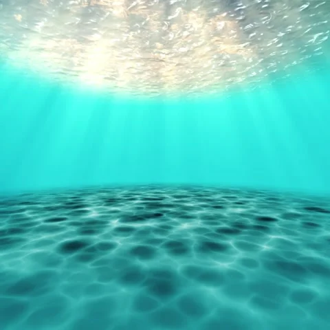 Underwater view looking up through clear turquoise ocean surface with sun rays 스톡 동영상 336574124