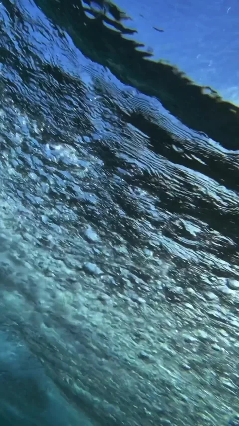 Underwater view of male surfer in the ocean.Vertical video Stock Footage 296169853