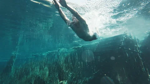 Underwater view of the man jumping and swimming in the crystal clear karst lake. Stock Footage 318601988