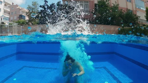 Underwater view of men jumping and swimming in the pool, slow motion Stock Footage 197594581