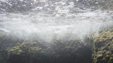 Underwater view of the ocean surface with splashing waves, air bubbles, and 動画素材 343242869
