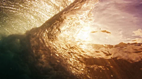 Underwater view of the ocean wave breaking on the shore at sunset. Stock Footage 221434953