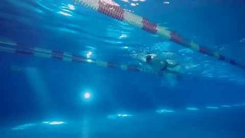 Underwater view to the professional swimmer swiming crawl stroke in the pool Stock Footage 75322173