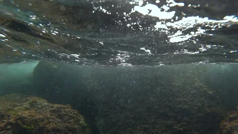 Underwater view revealing surface water with bubbles and sunlight refracting, 스톡 동영상 343101995