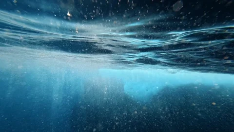 Underwater view of rippling surface and and bubbles in blue water Stock Footage 345844738